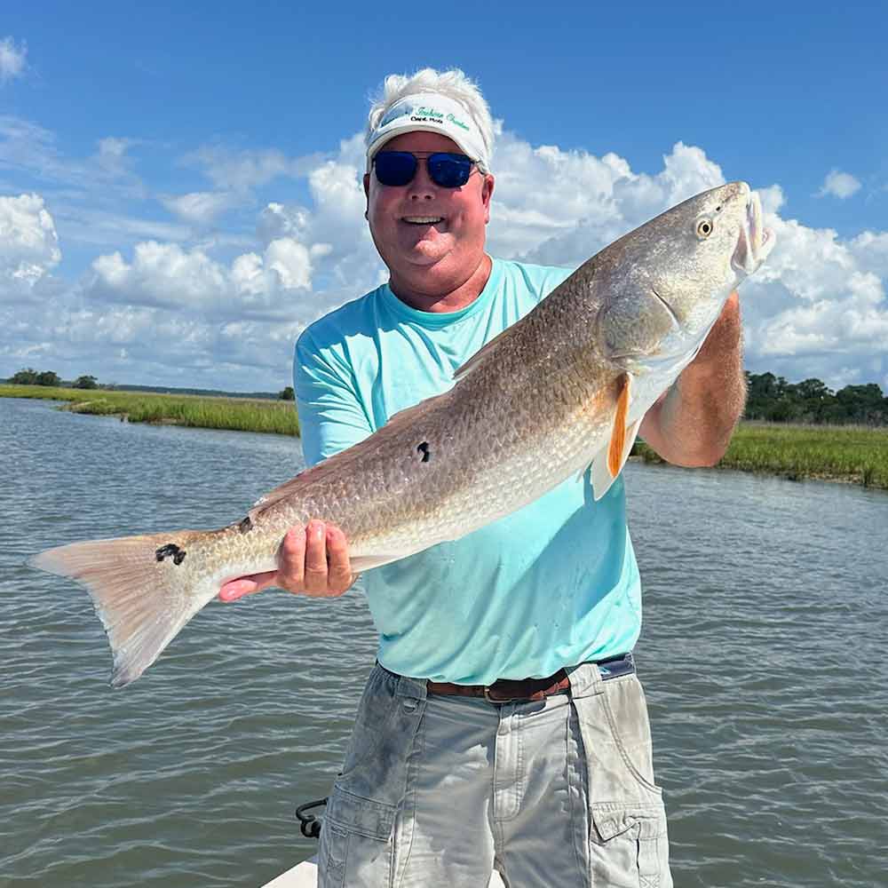 Captain Rob Bennett with a bigger grade of redfish