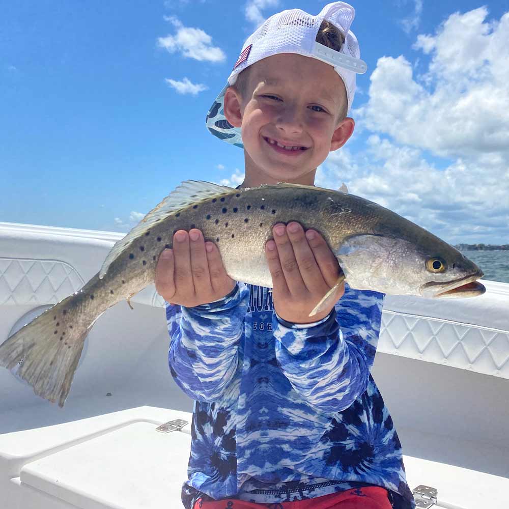 A happy young angler shows off a trout caught with Captain Addison Rupert