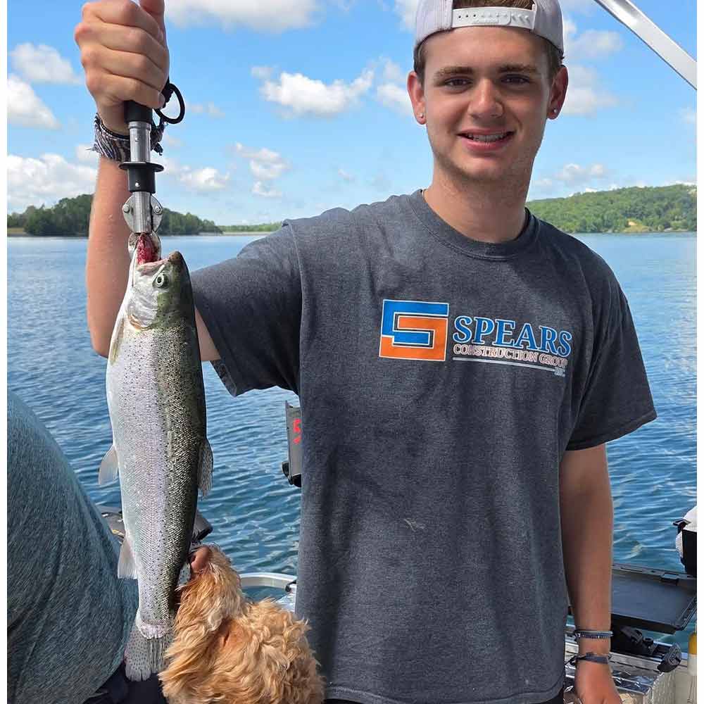 Fisher inspects and approves a rainbow caught with Jocassee Charters 